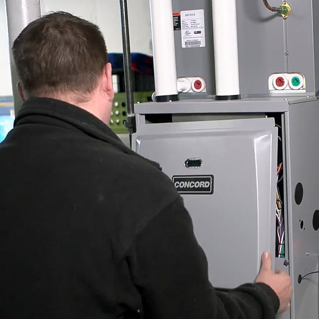 A Reimer technician re-inserts the faceplate of this furnace back in place after finishing up repairs.