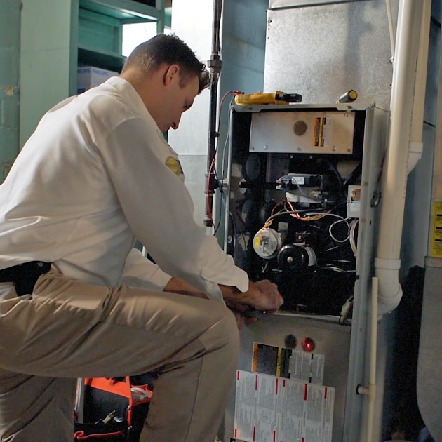 A Reimer heating repair specialist works on a furnace as part of our heating repair in Tonawanda, NY.