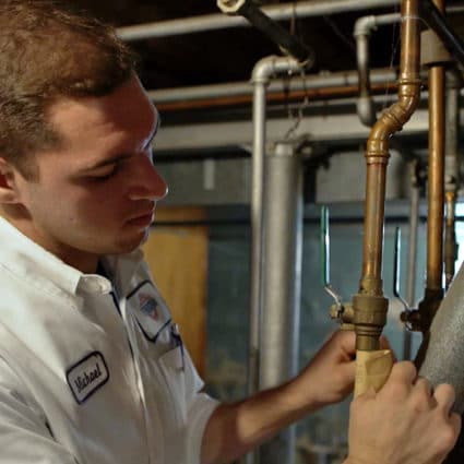 A Reimer plumber applies a label to the pipes of this home, taking the time to do the job right.