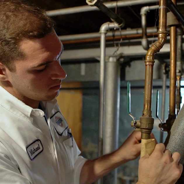 A Reimer plumber applies a label to the pipes of this home, taking the time to do the job right.