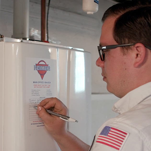 Our plumber adds a note to this tankless water heater, indicating when it was last serviced.